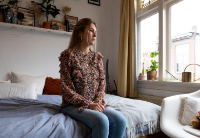 Student in bedroom, looking worried